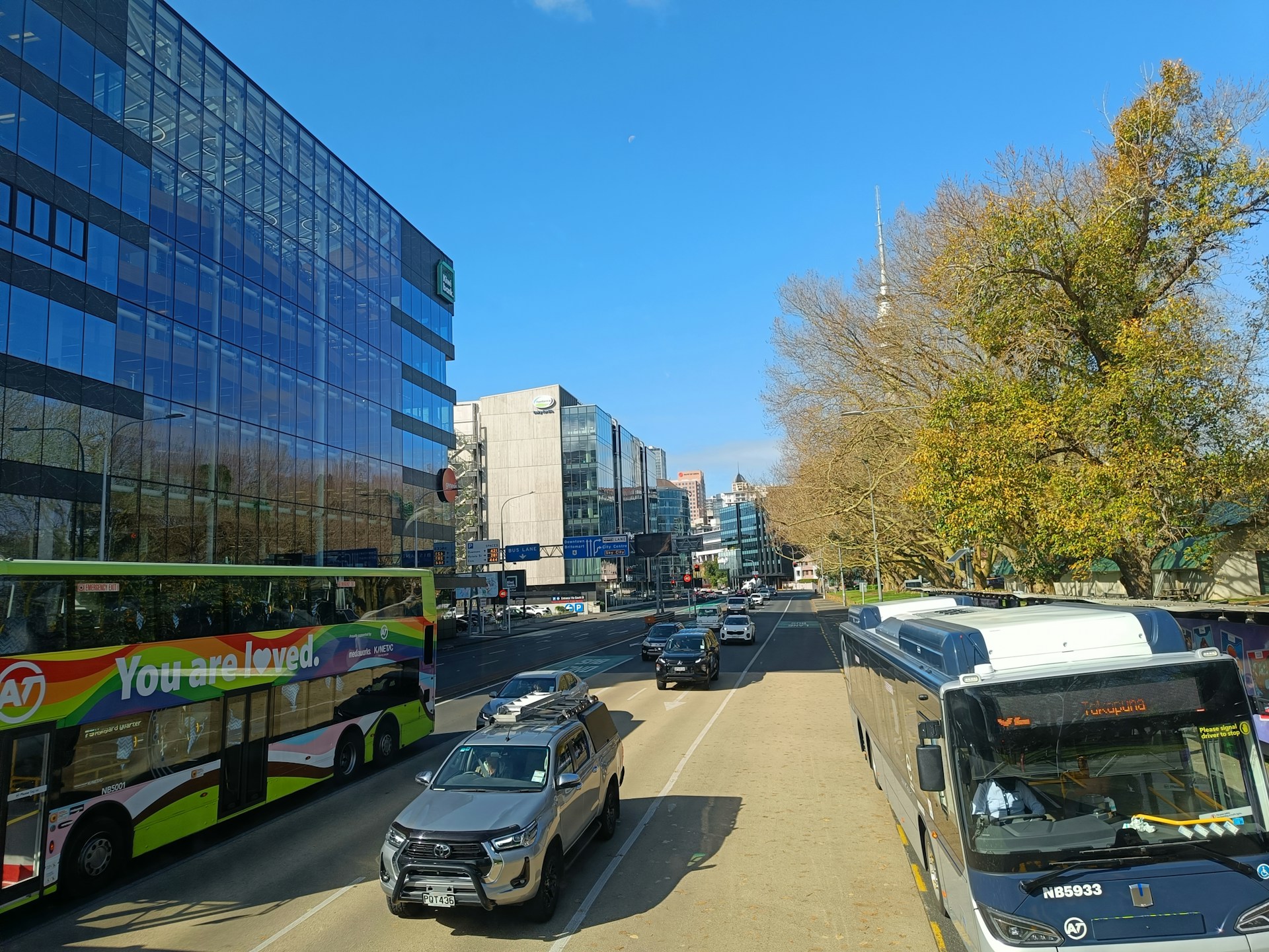 A city street filled with lots of traffic next to tall buildings