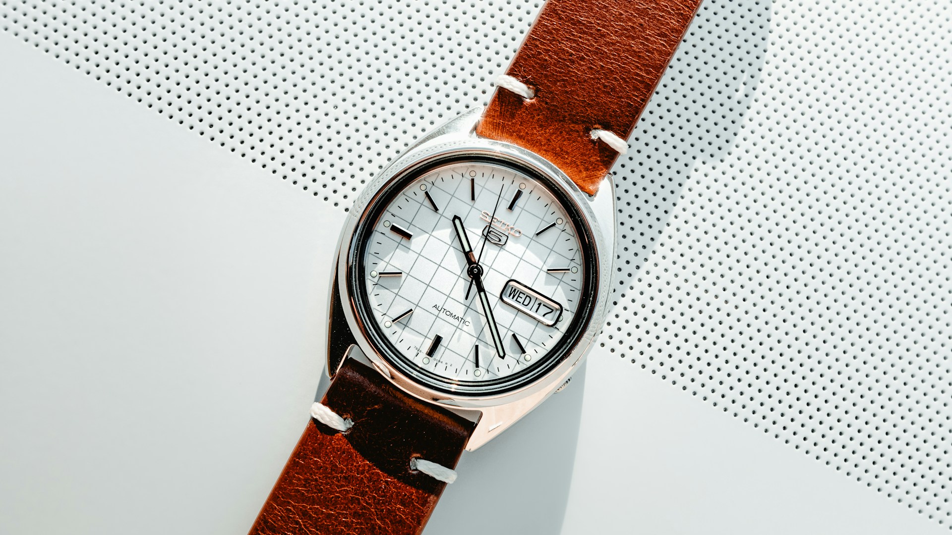 A watch sitting on top of a white surface