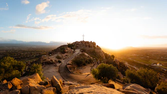 The sun is setting over a rocky hill