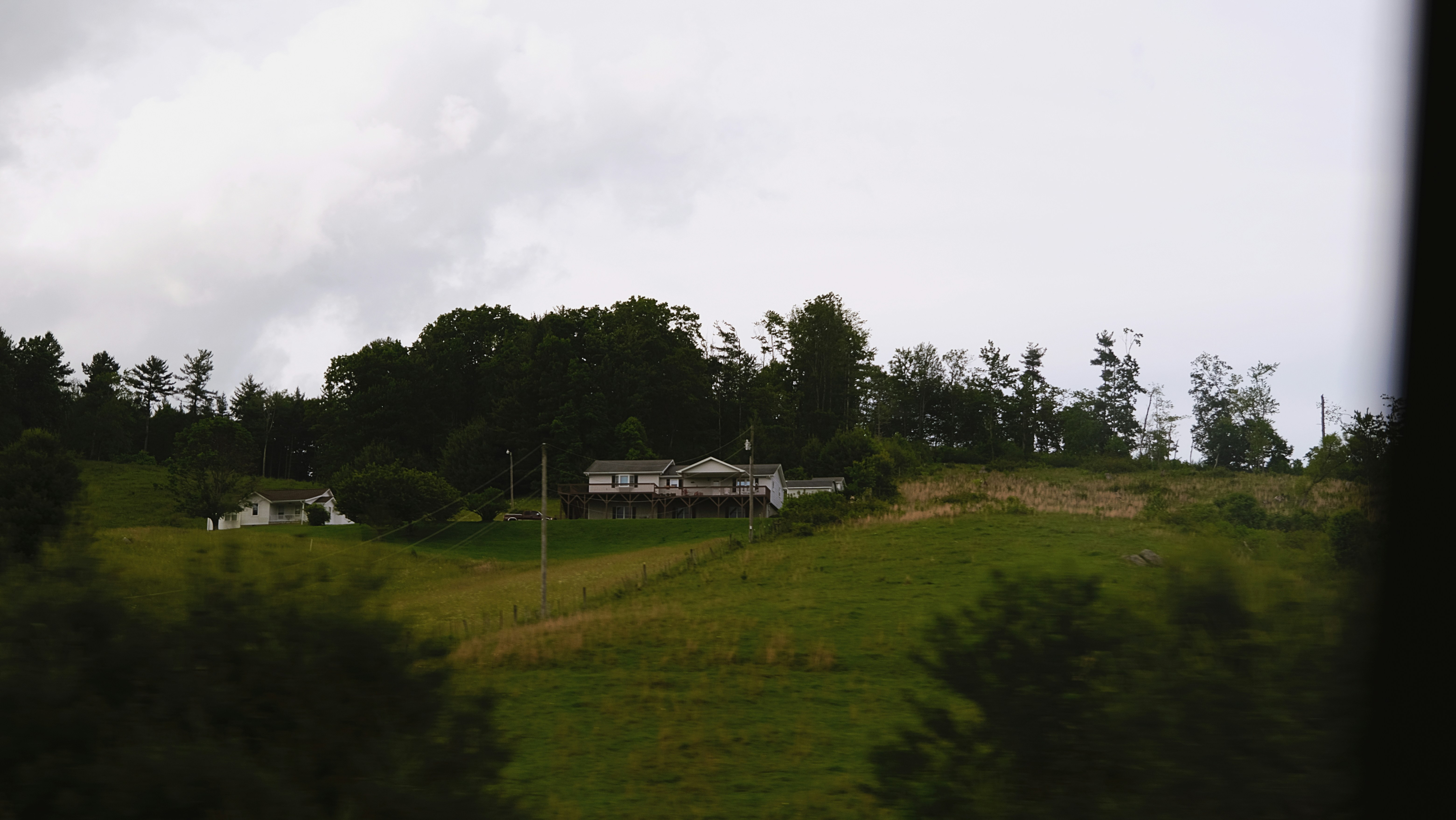 A house on a hill with trees in the background