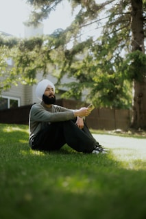 A man sitting in the grass with his feet crossed