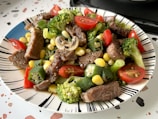 A white plate topped with meat and veggies