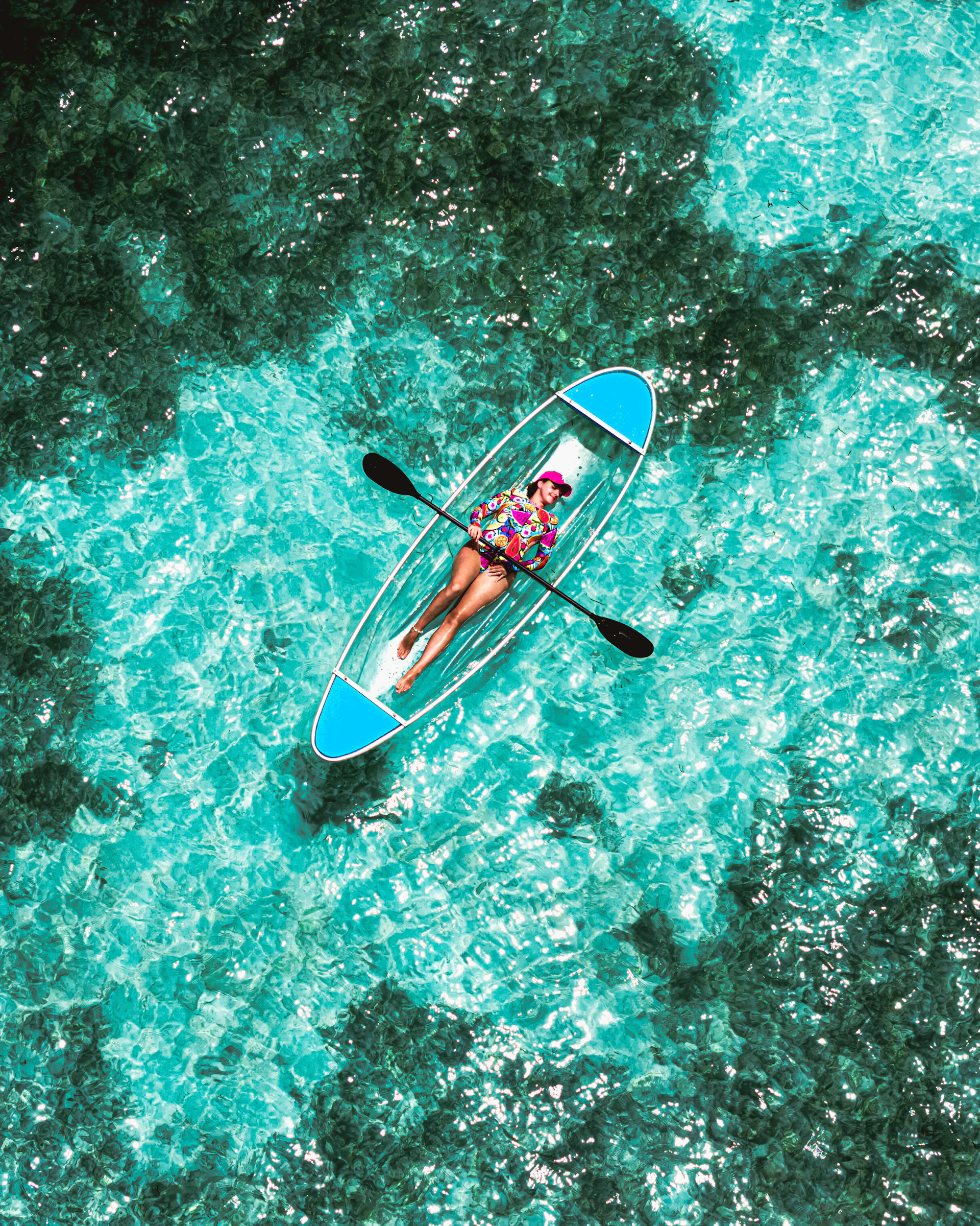 A person in a blue kayak in the middle of the ocean