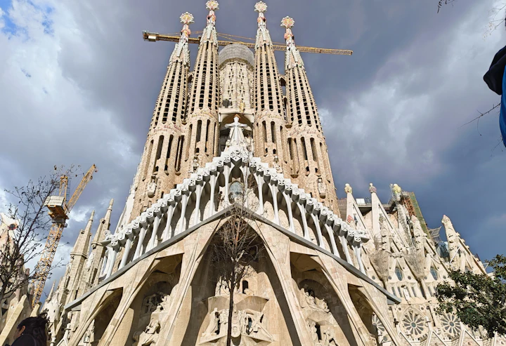De Passiegevel van de Sagrada Família onder een bewolkte lucht
