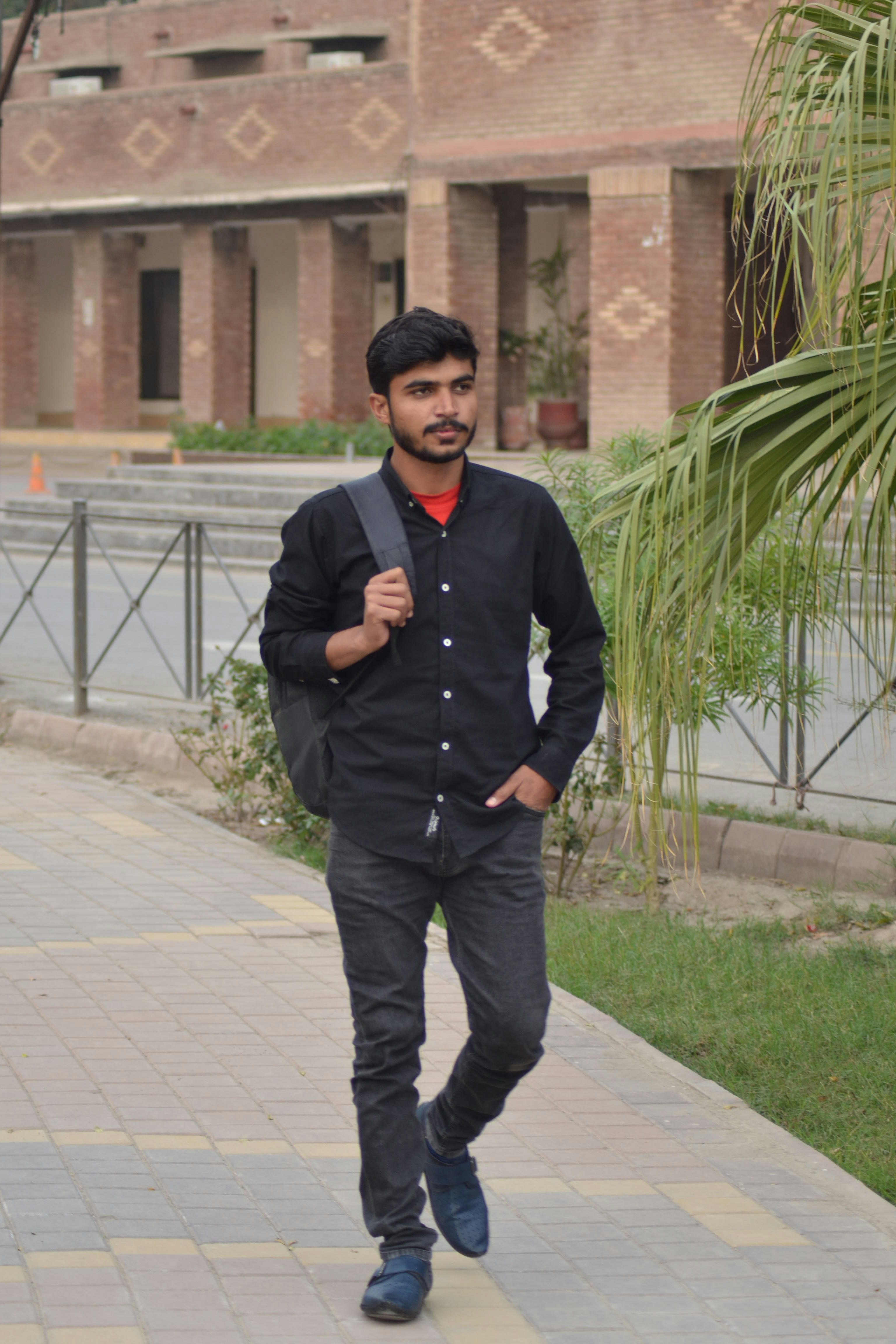 A man walking down a sidewalk with a backpack