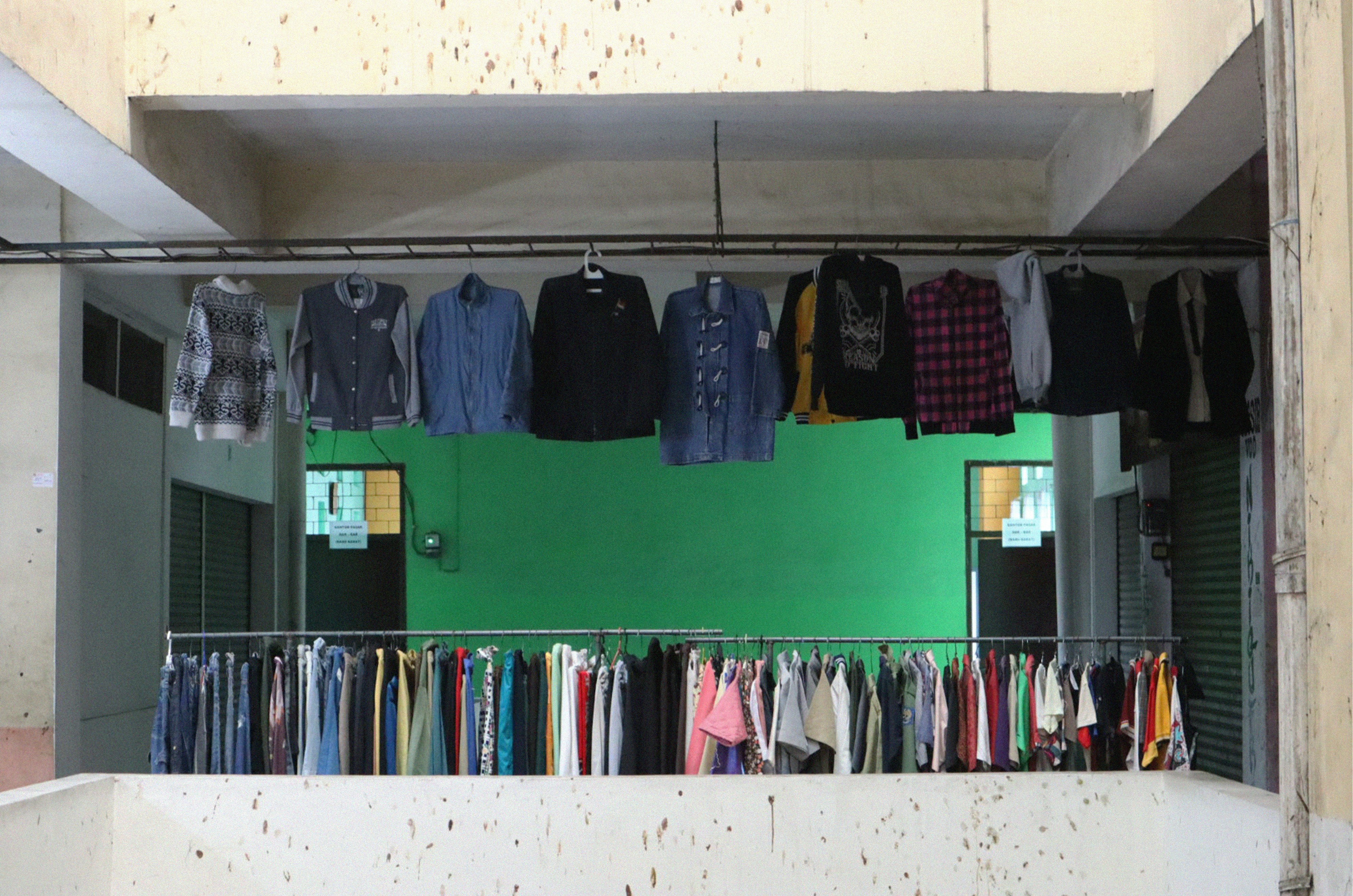 Room filled with clothes and green wall
