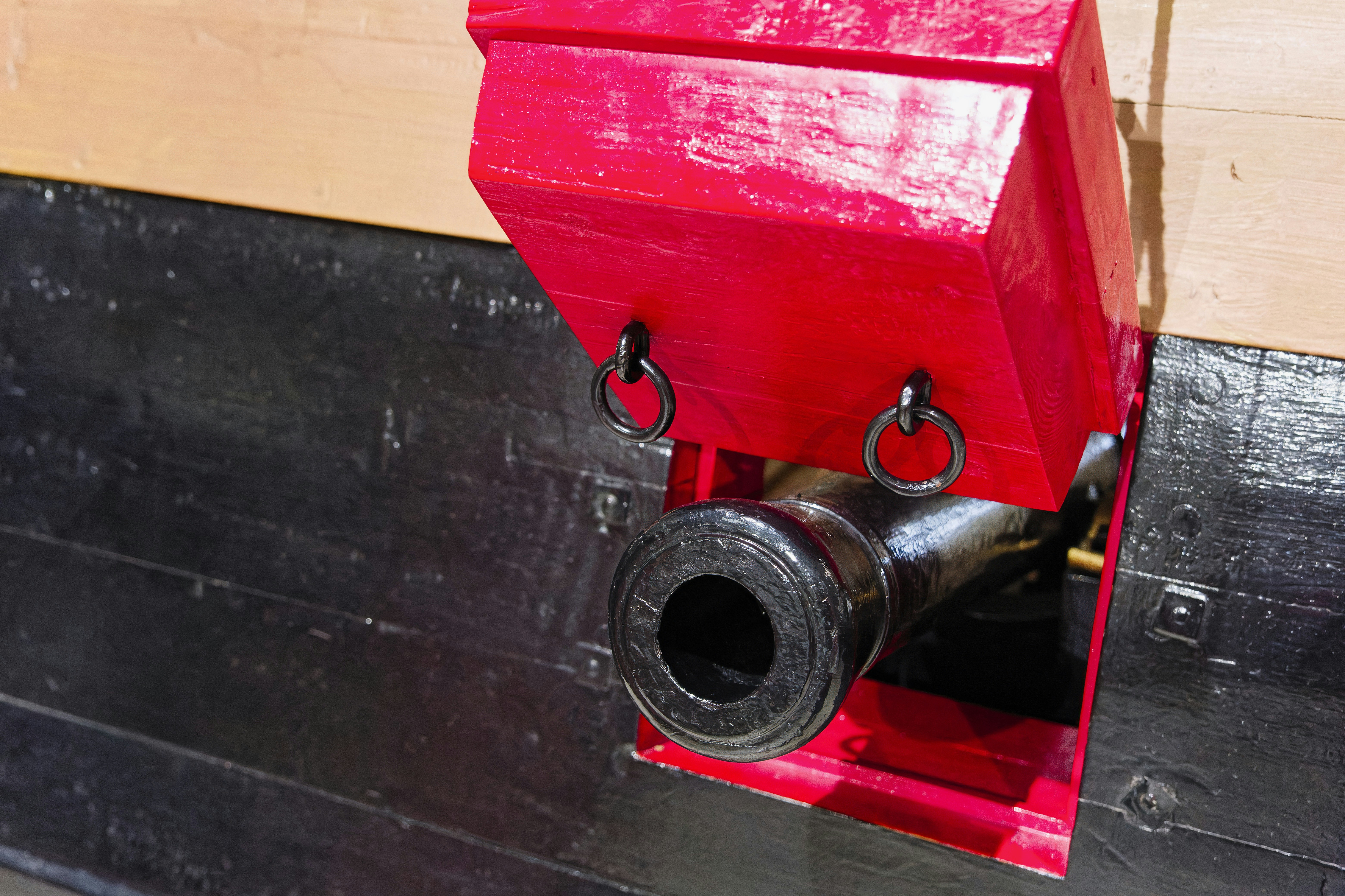A red fire hydrant mounted to the side of a building