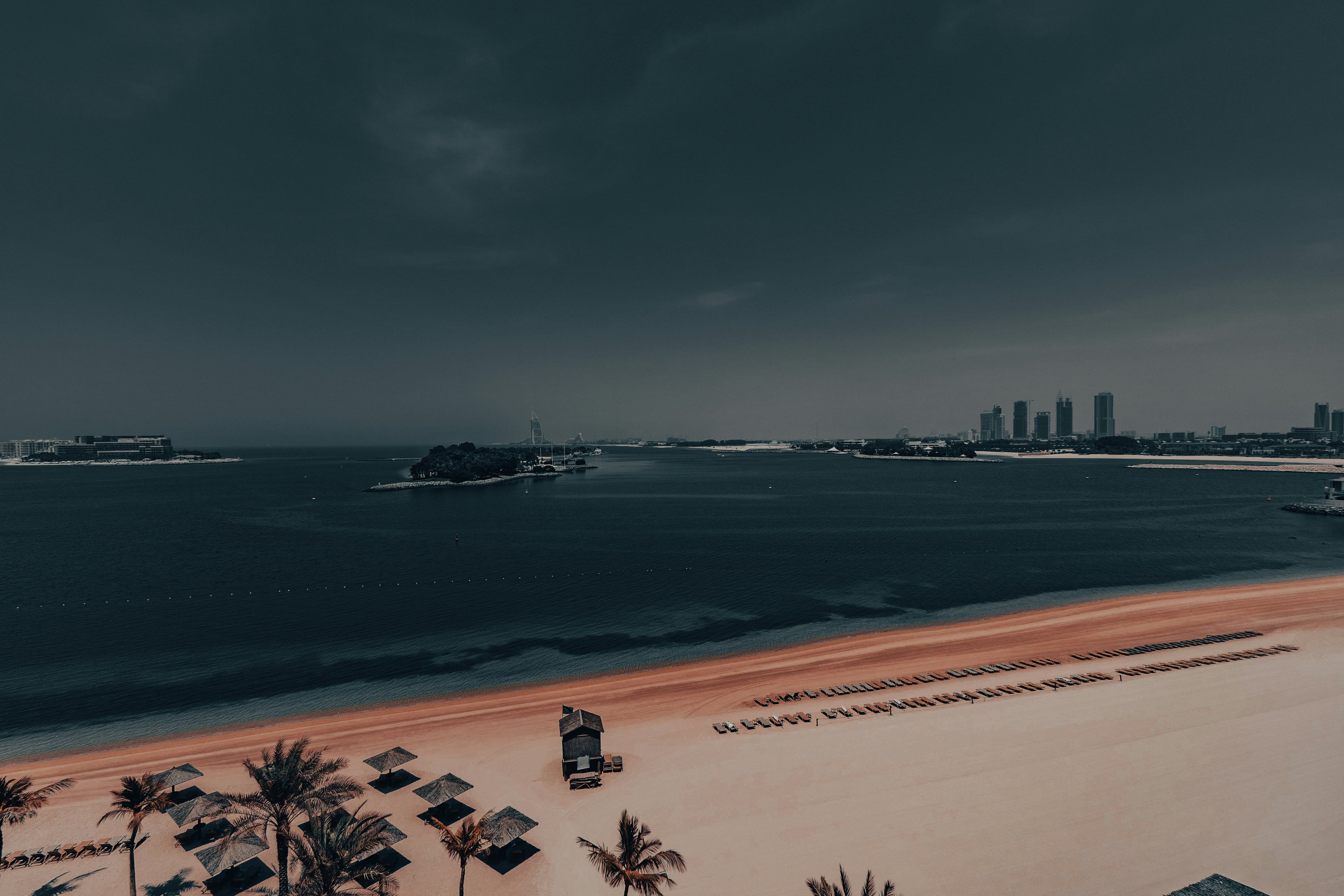 An aerial view of a beach with boats in the water