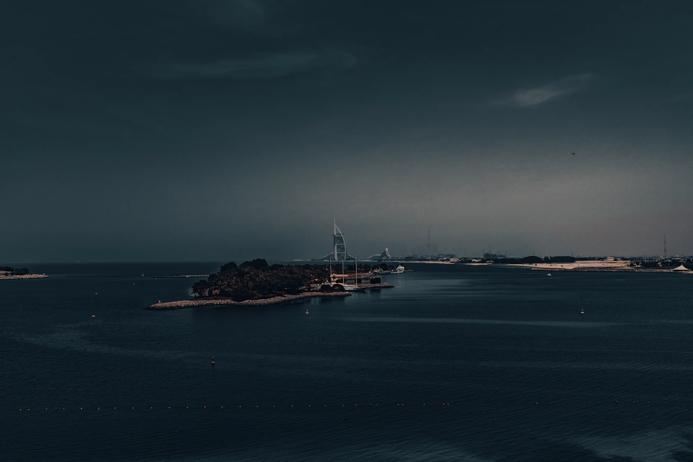 Palm Jumeirah mit beleuchteter Skyline bei Nacht
