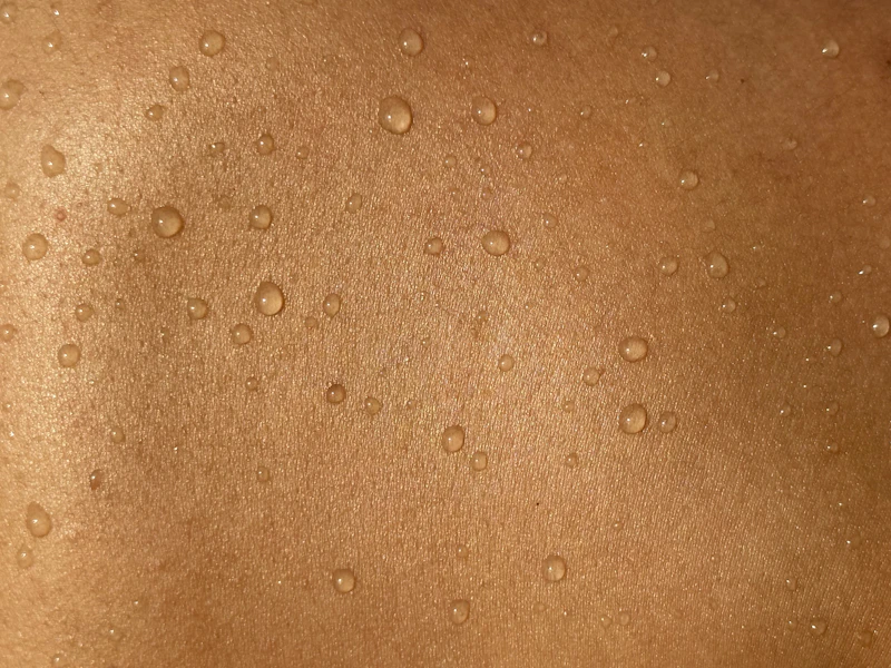 Costas com gotas de água, foco na pele