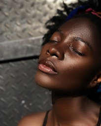 A woman with her eyes closed and her hair in a bun