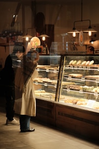 A woman standing in front of a bakery window
