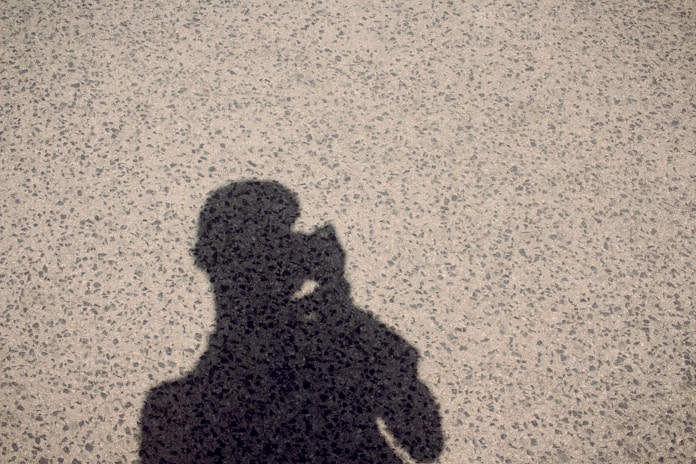 A shadow of a person holding a cell phone