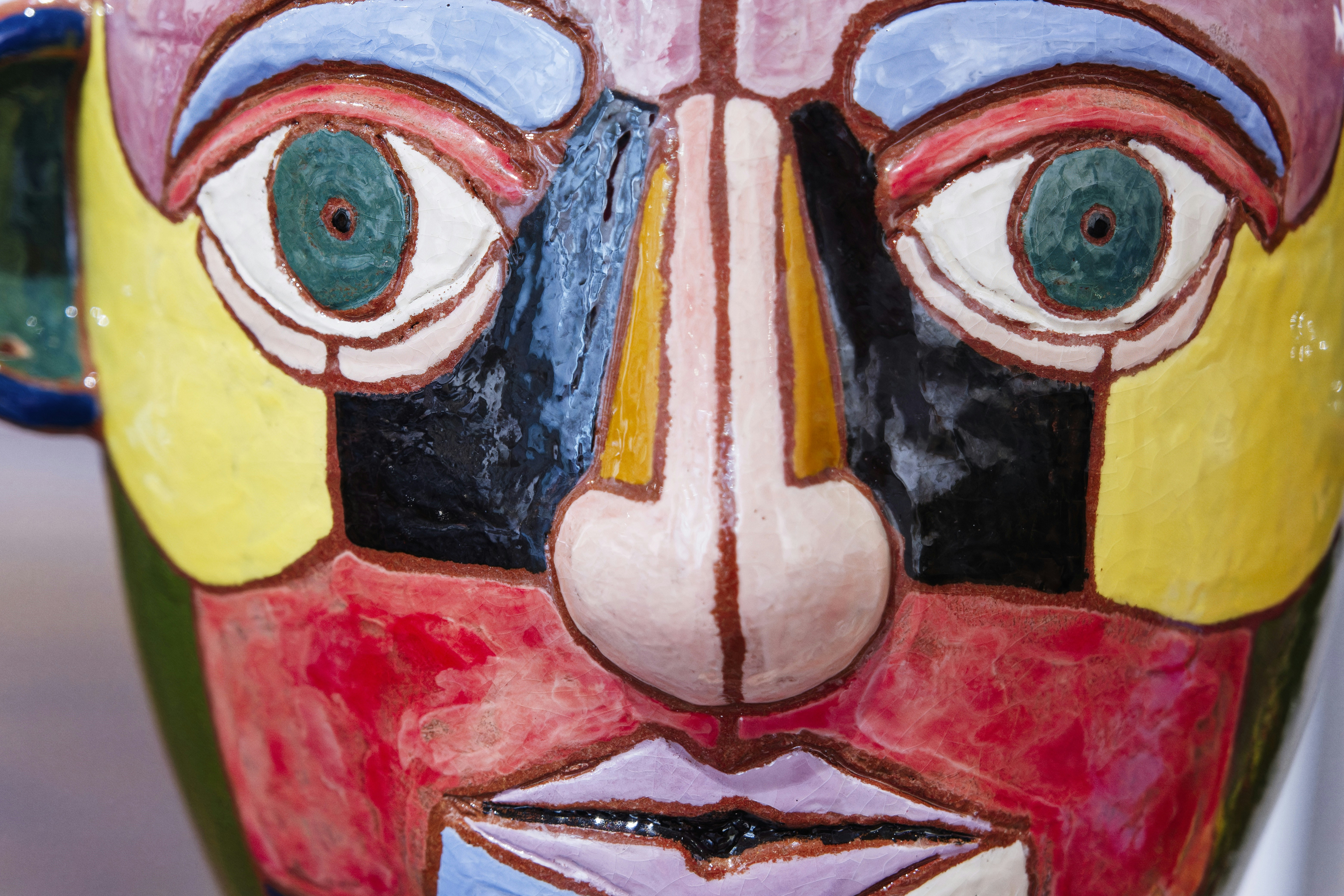 A close up of a colorful mask on display