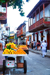 A cart filled with lots of oranges on a street
