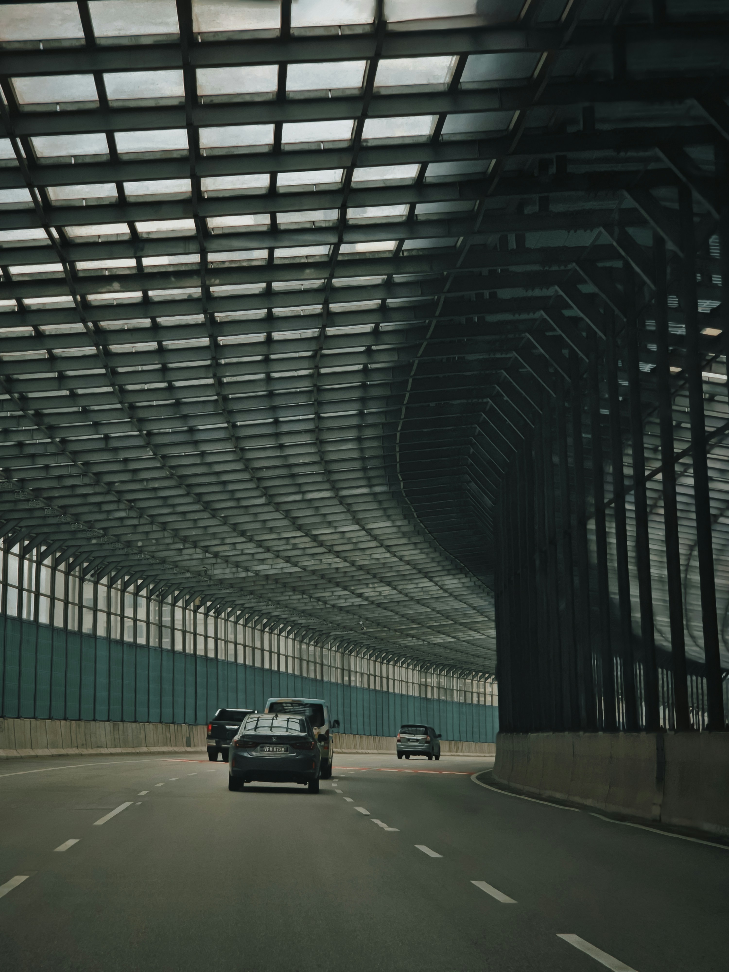 Une voiture roulant sur une autoroute à côté d’un grand immeuble