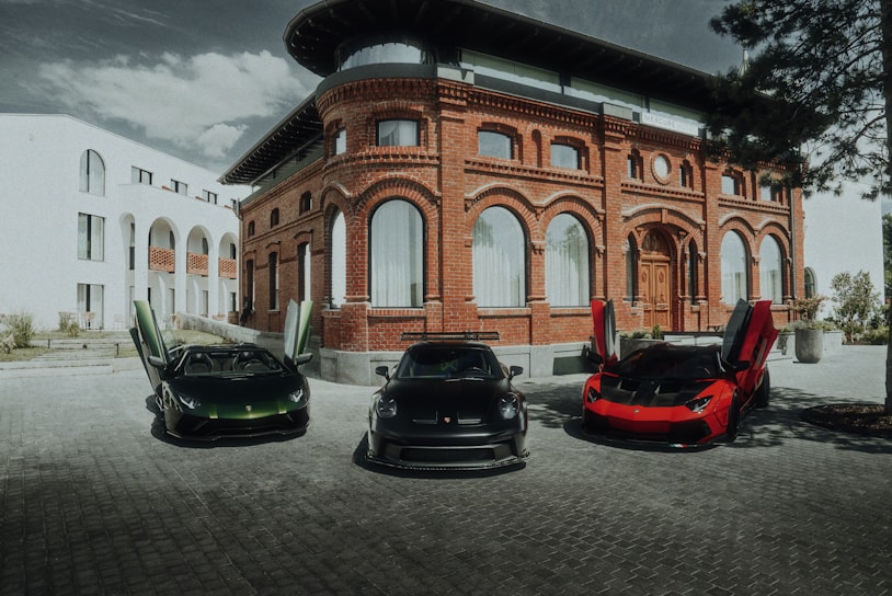 Three cars are parked in front of a building