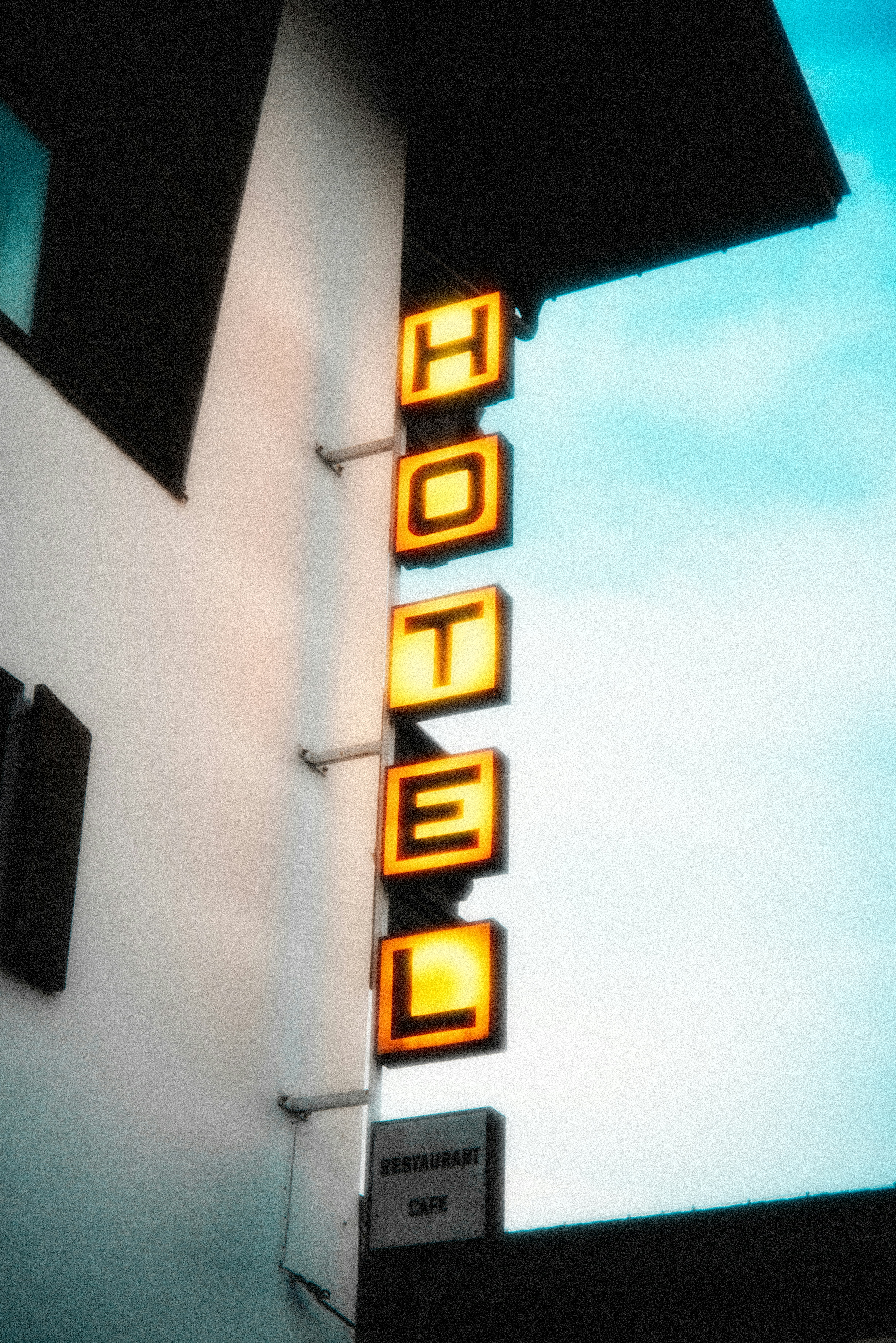 A neon hotel sign on the side of a building