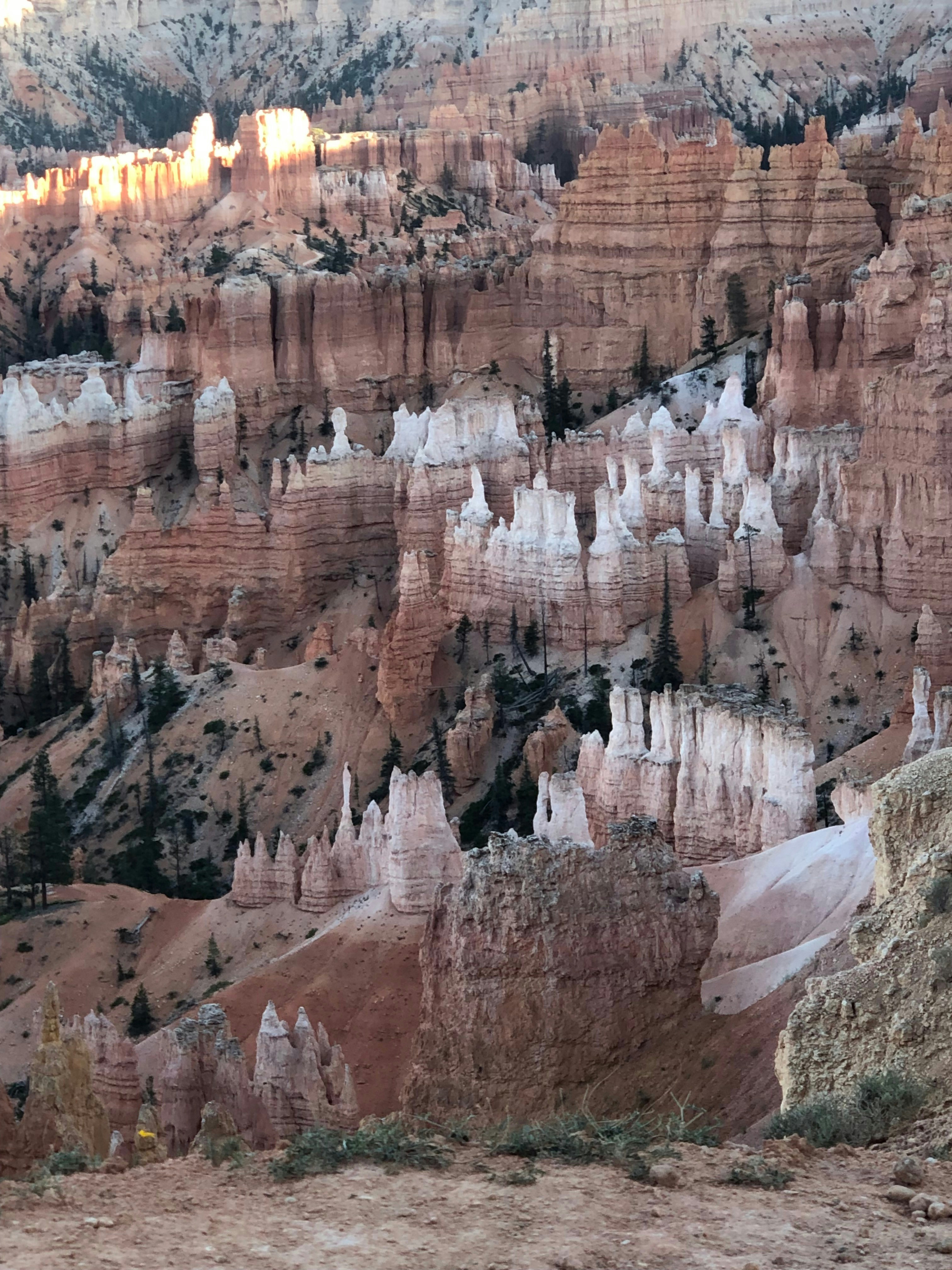Makoshika State Park badlands formations at golden hour, ancient rock spires under warm sky