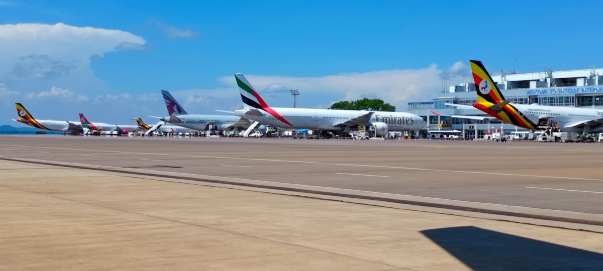 Uganda Airlines, Emirates, Qatar Airways and Kenya Airways jets parked in front of the terminal at Entebbe