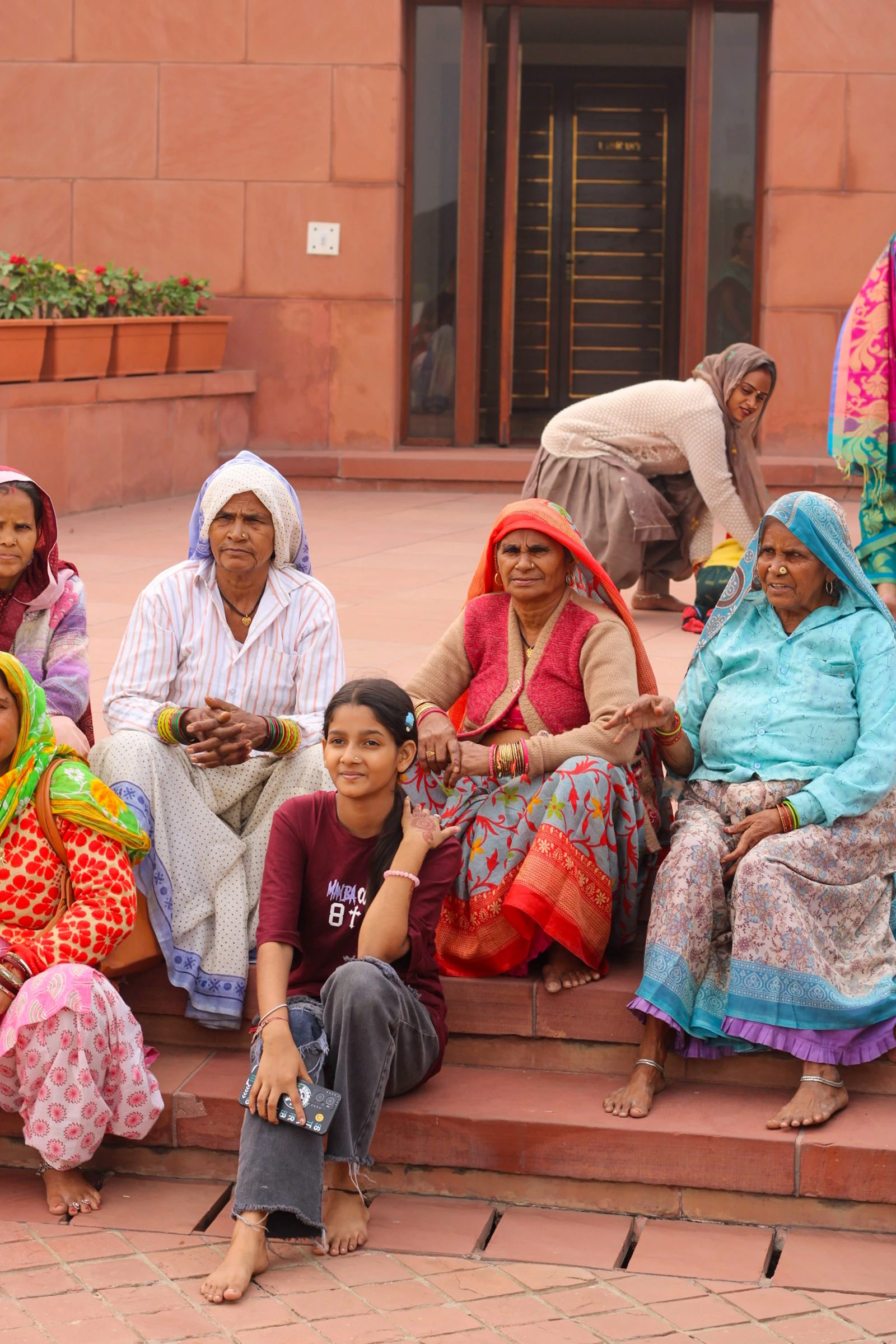 A group of women sitting on the steps of a building