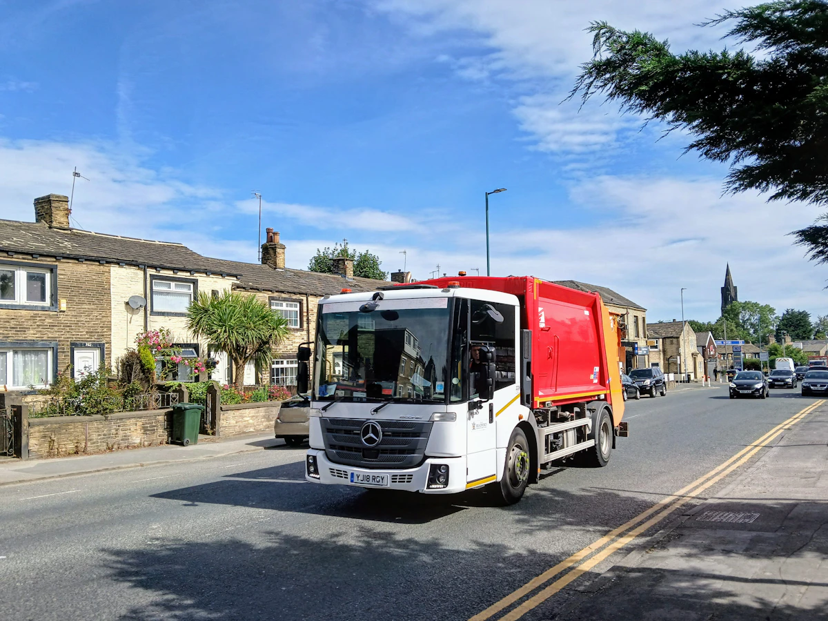 A council refuse collection lorry on a residential street in England