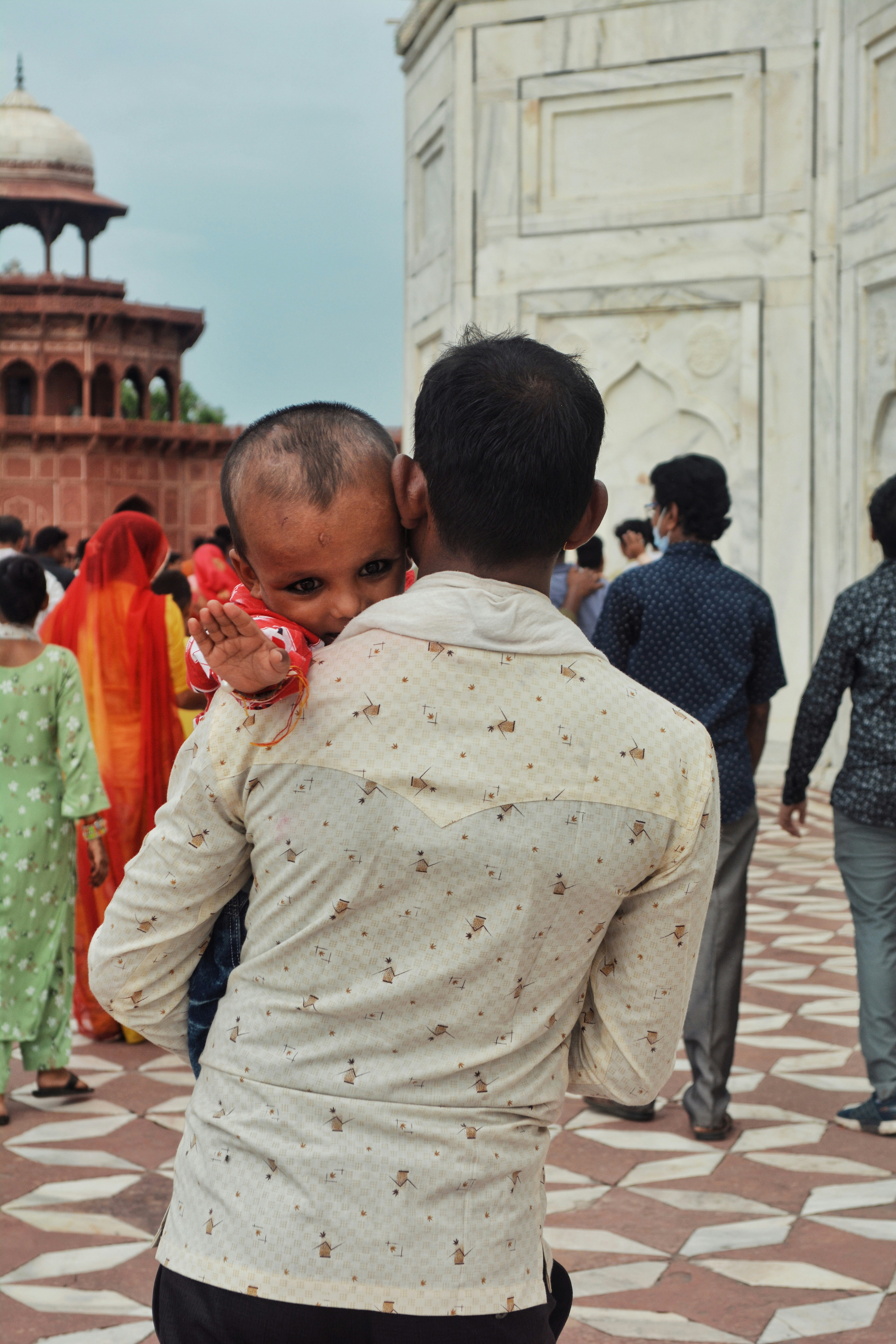 A man holding a baby in front of a building