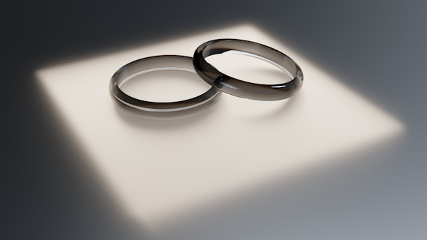 Two wedding rings sitting on top of a white surface