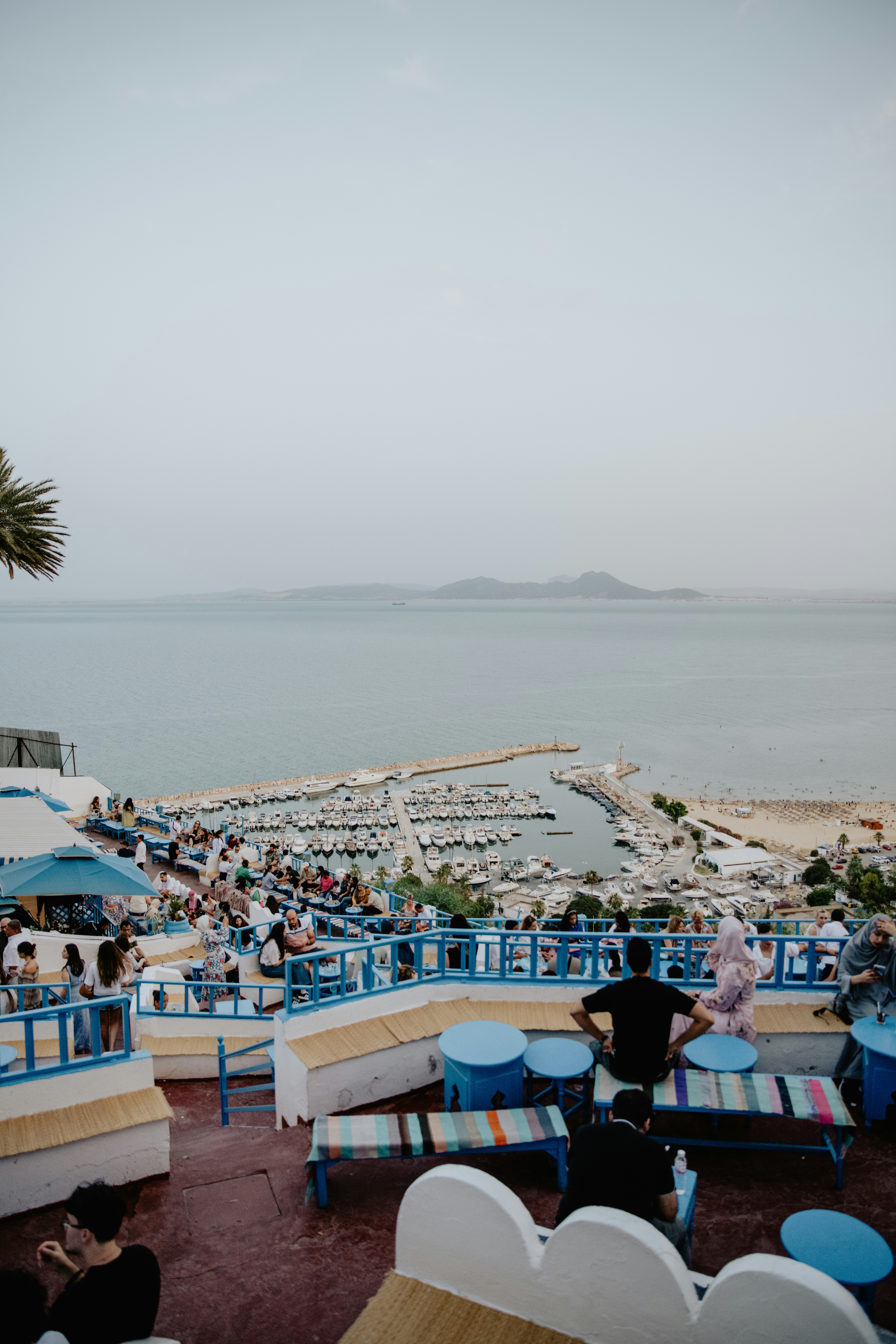 Um grupo de pessoas sentadas em mesas perto do oceano