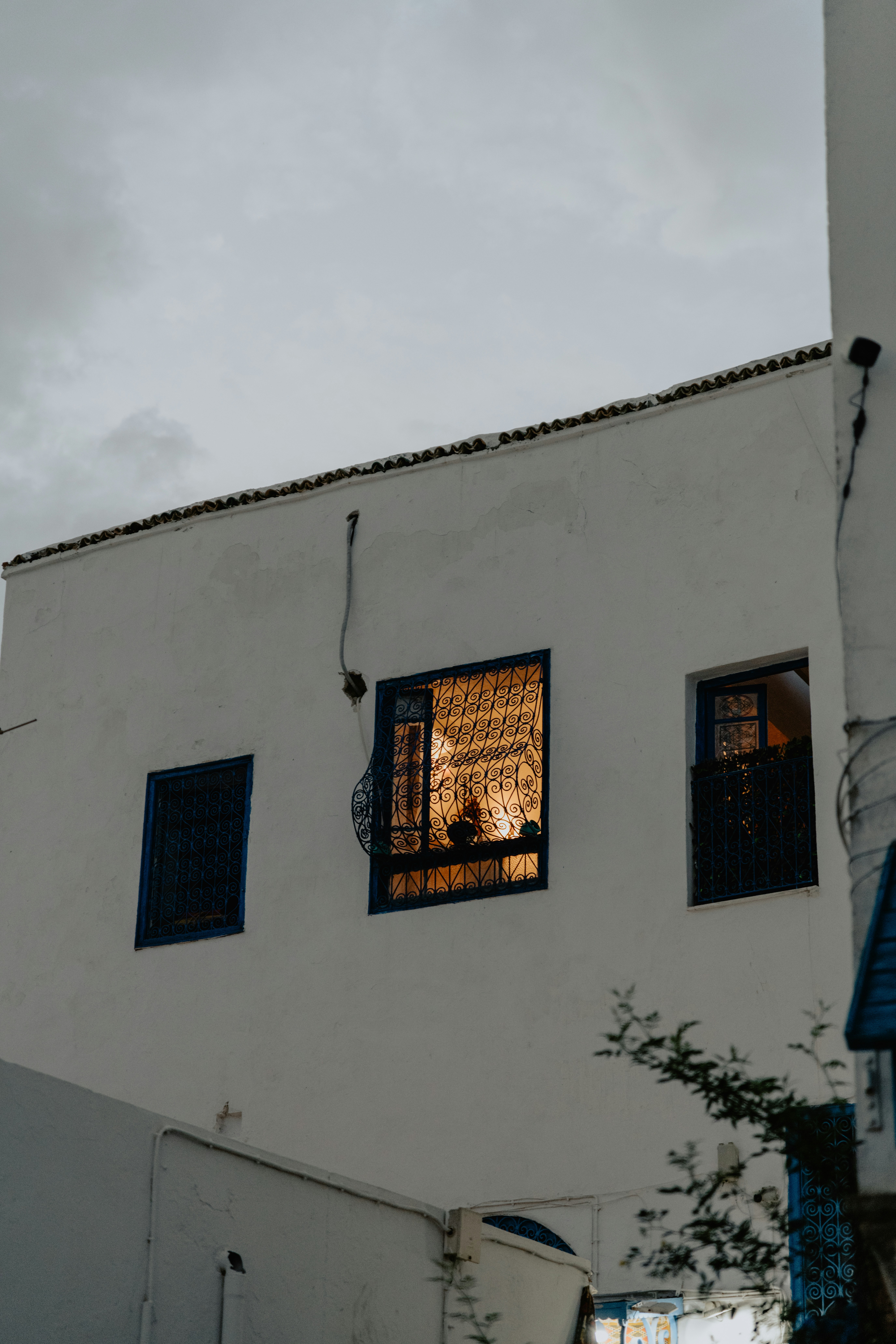Um edifício branco alto com janelas e uma torre do relógio