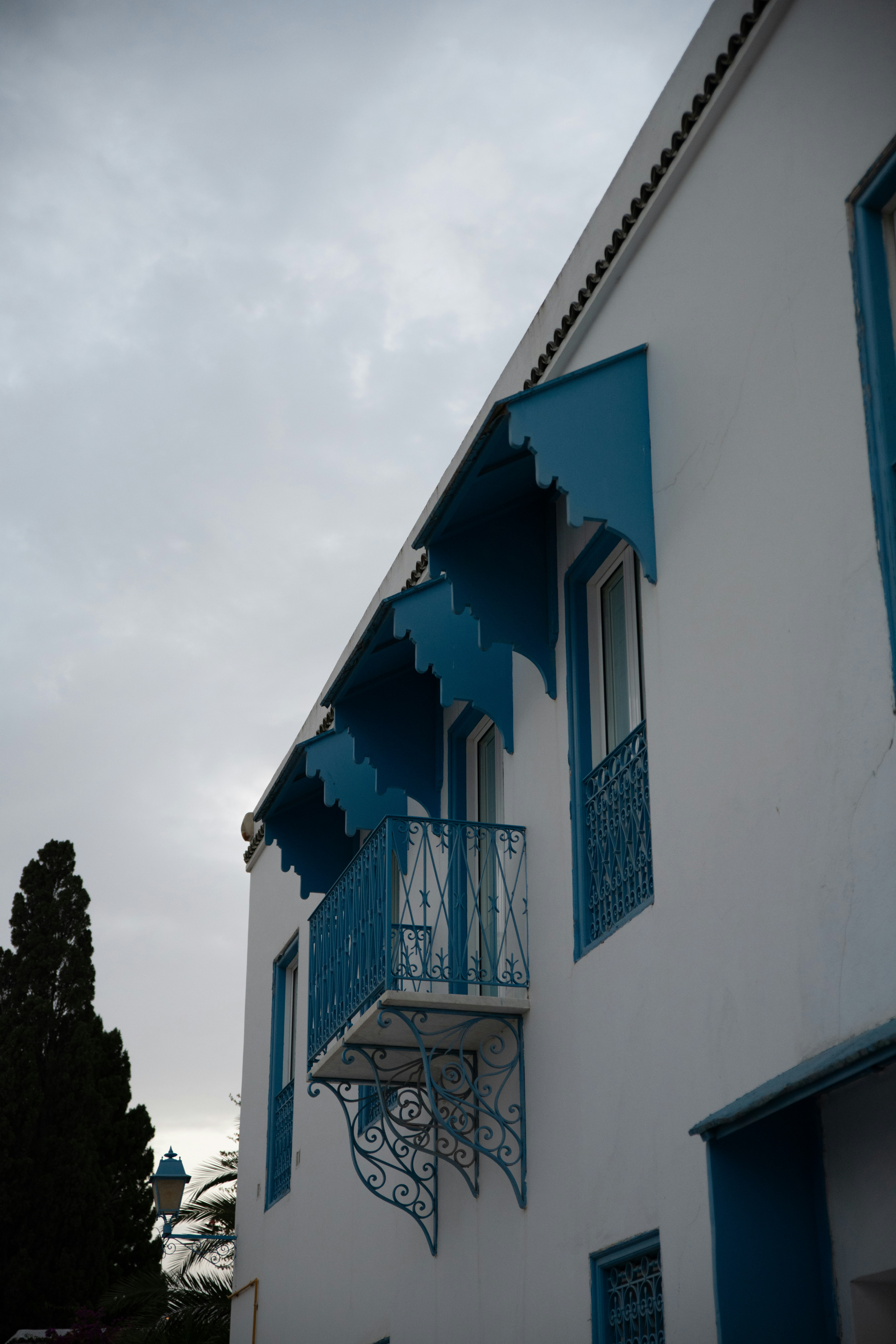 A white and blue building with blue balconies