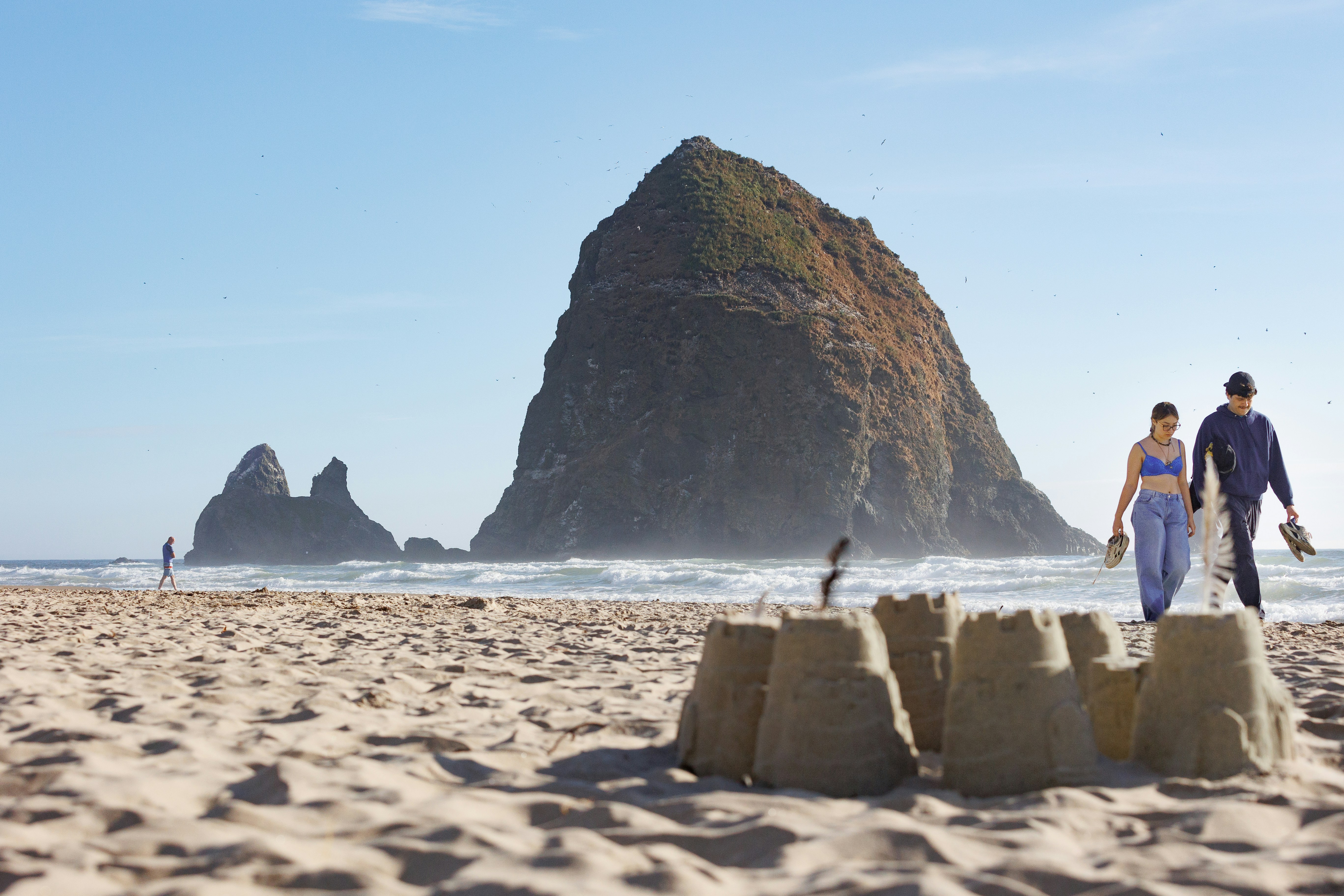 A man and a woman are walking on the beach