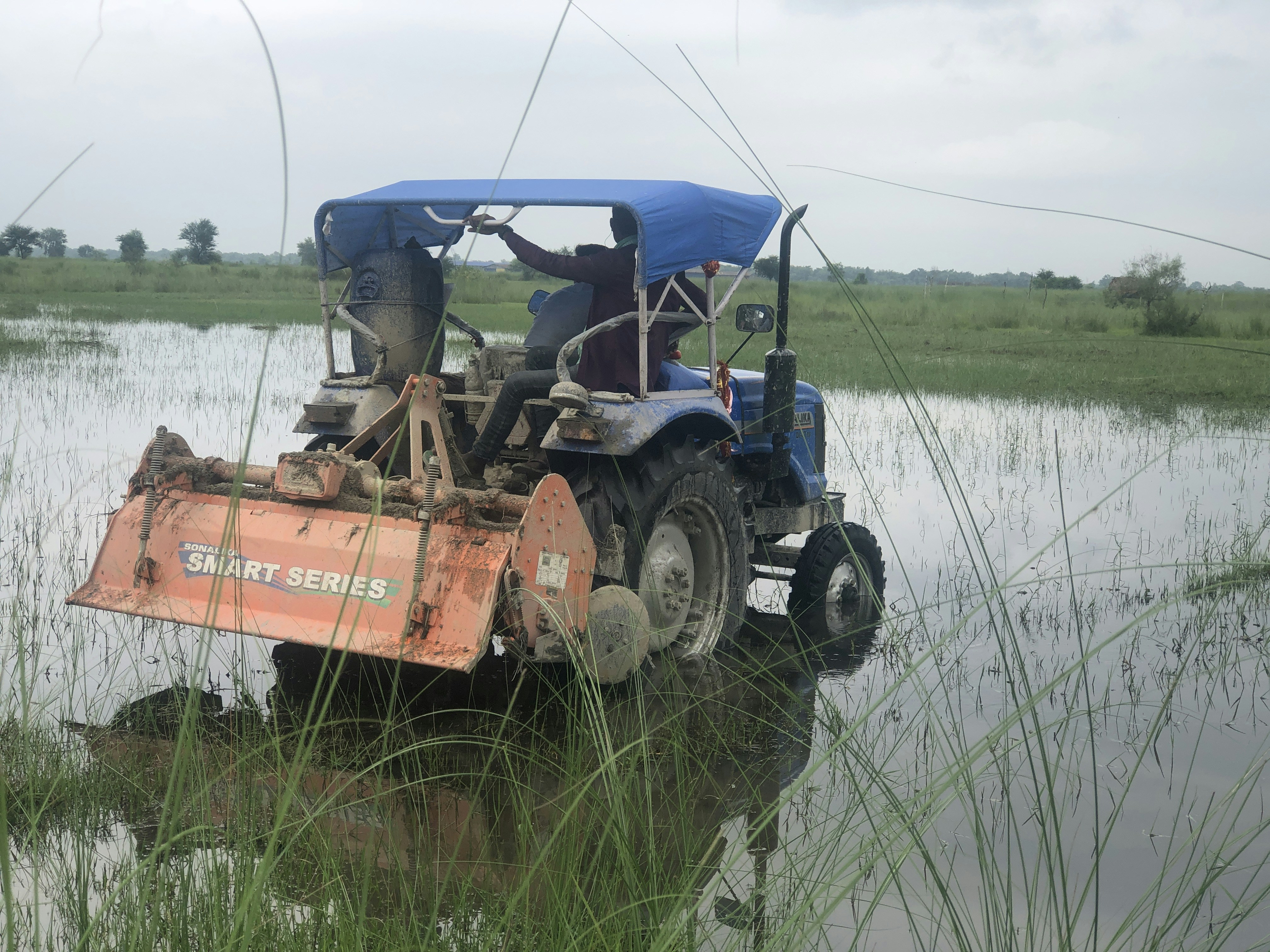 A tractor that is sitting in some water photo – Free Outdoors Image on ...