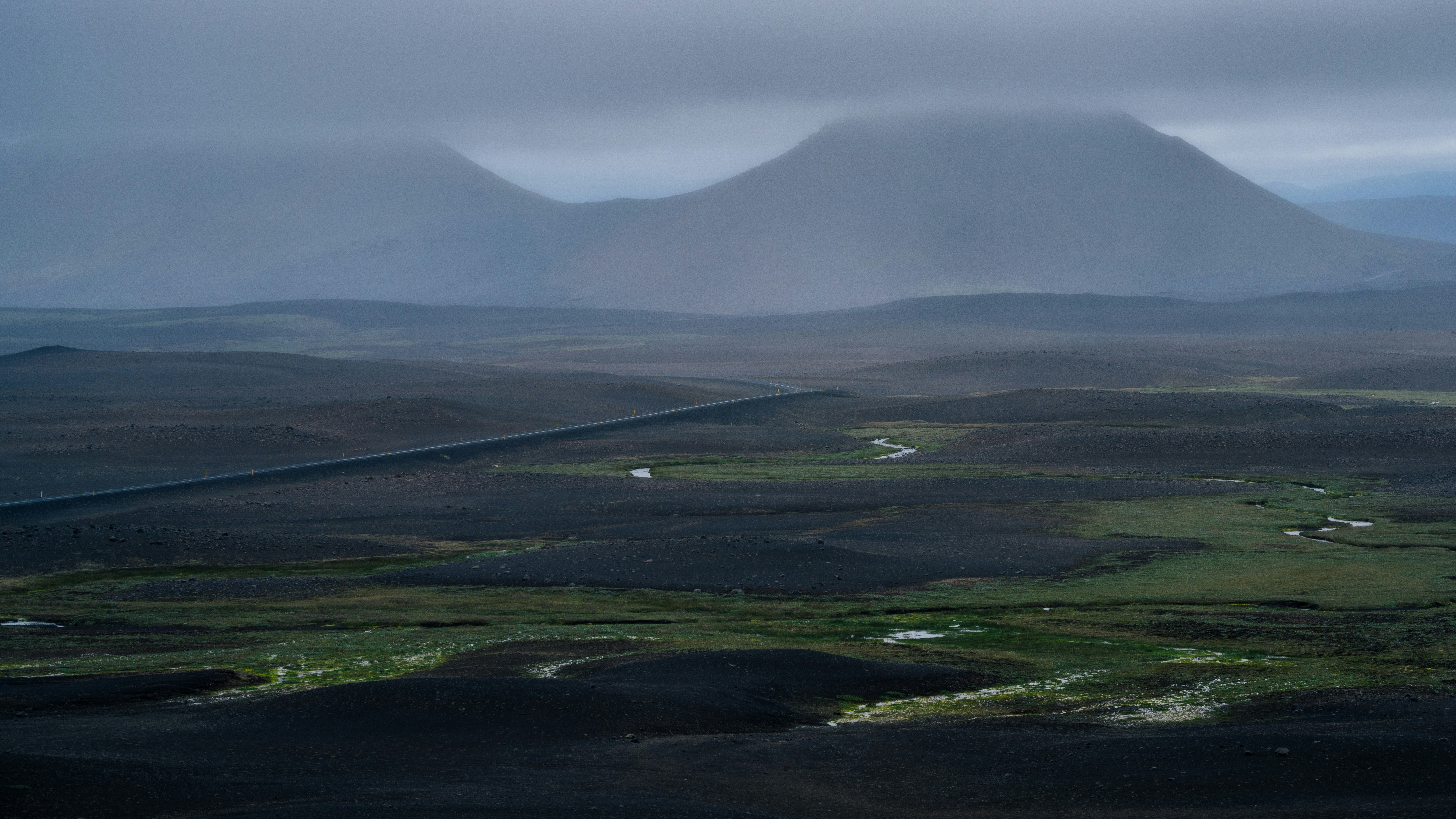 An aerial view of a mountain range with clouds in the sky