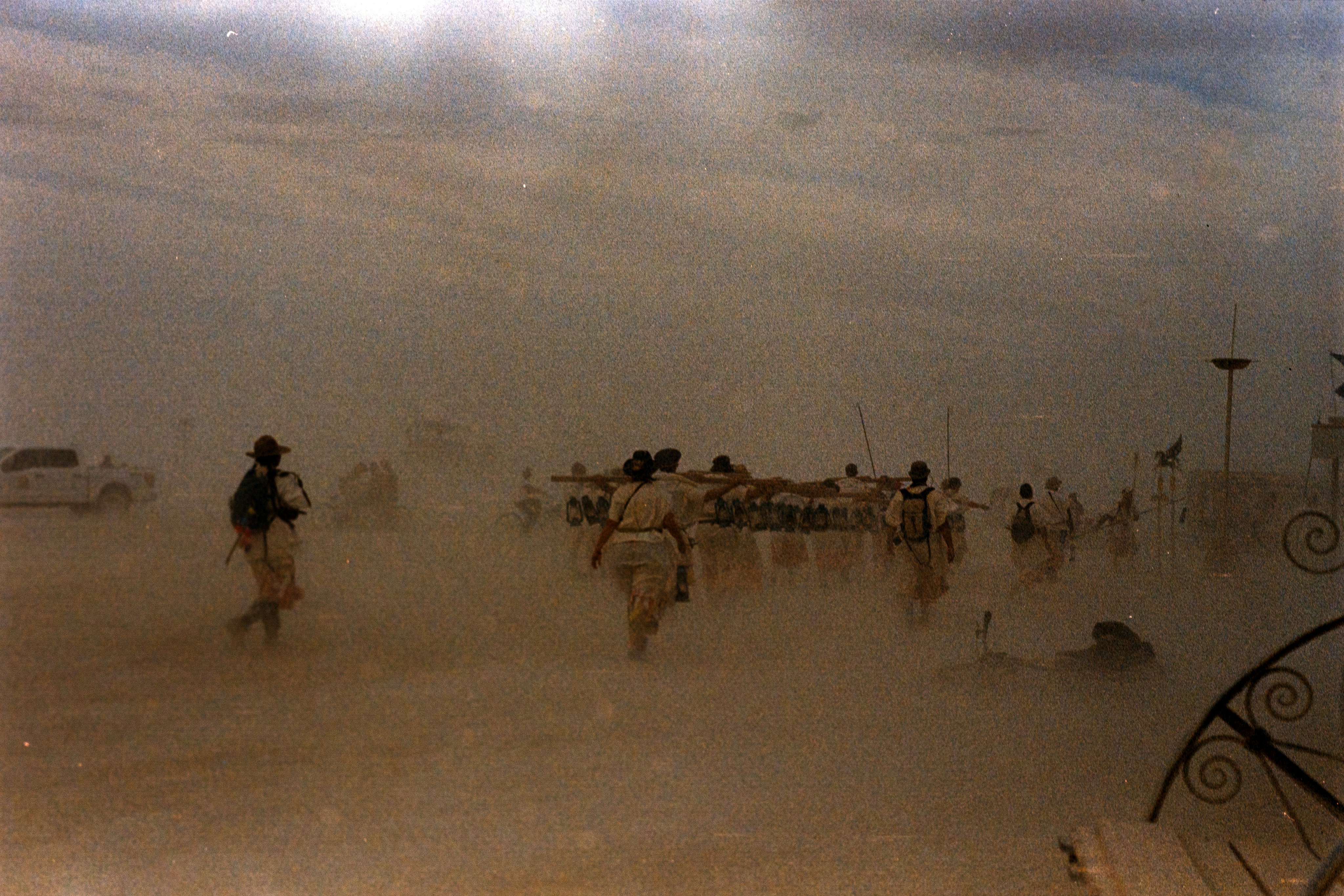 A group of people walking across a sandy beach