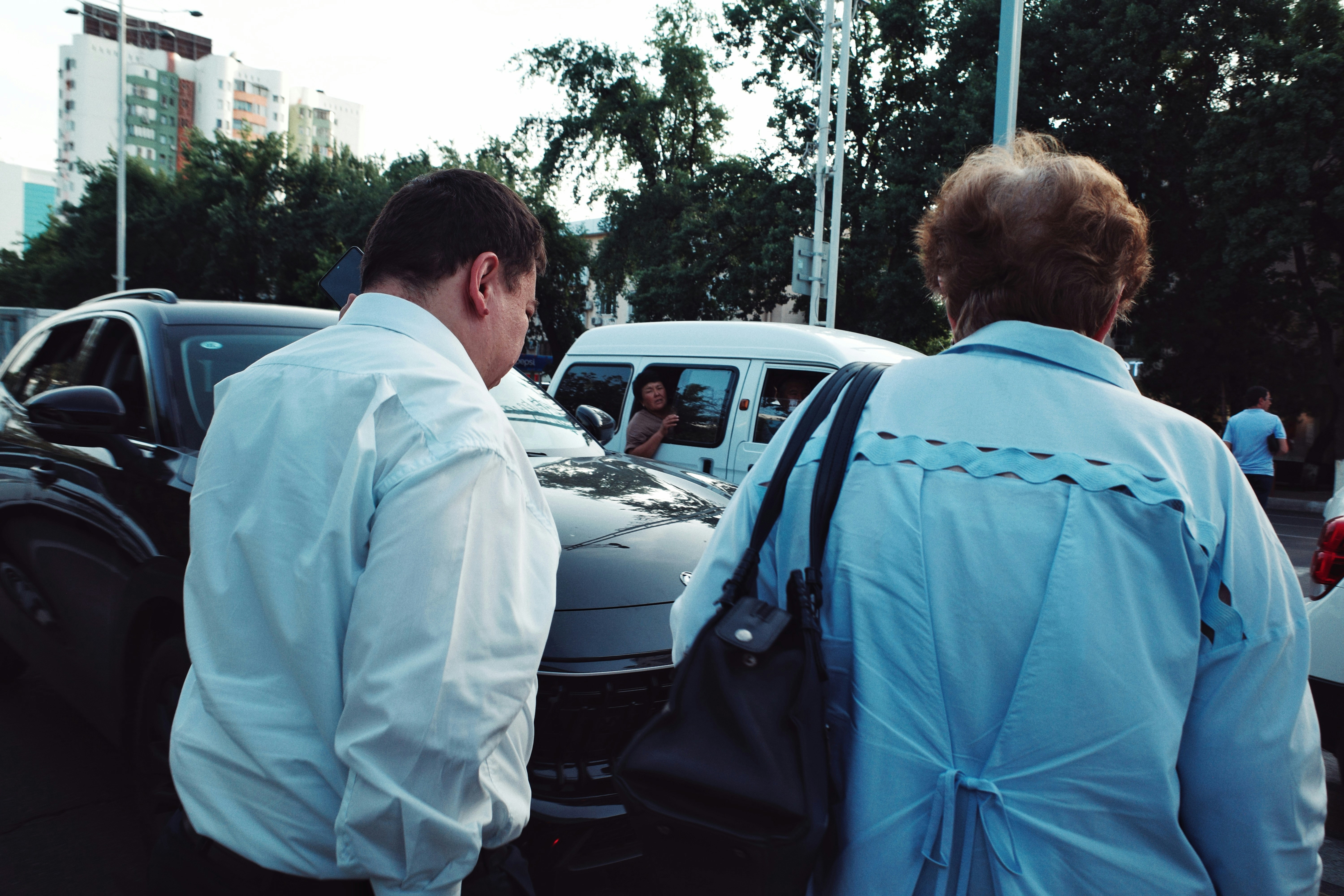 Police officers questioning someone near a taxi, with a serious expression.