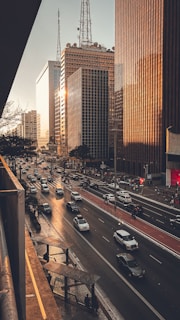 A city street filled with lots of traffic next to tall buildings
