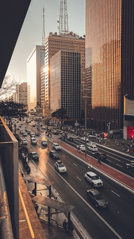 A city street filled with lots of traffic next to tall buildings