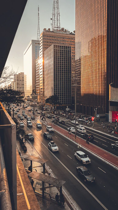 A city street filled with lots of traffic next to tall buildings