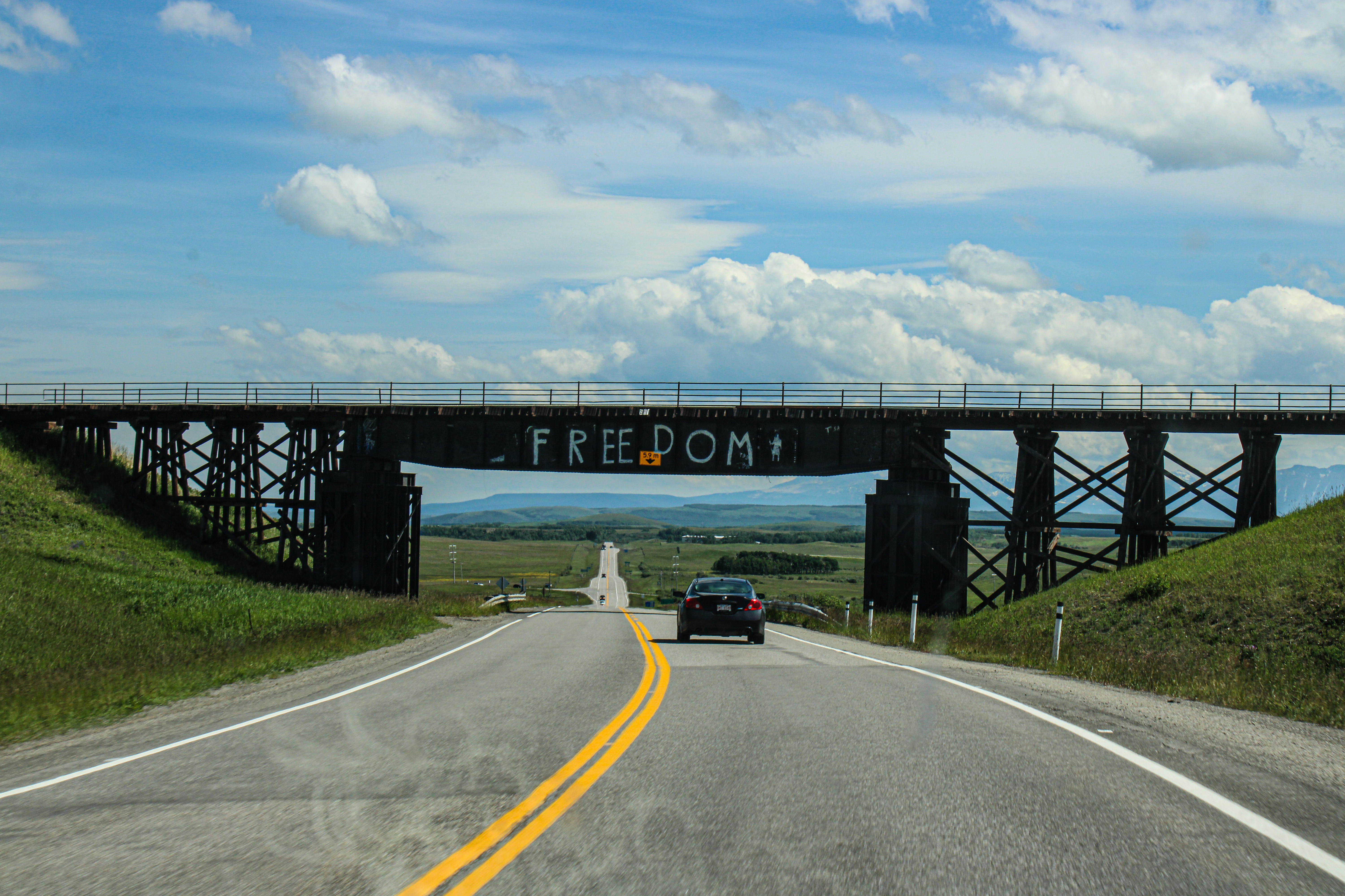 A car driving down a road under a bridge