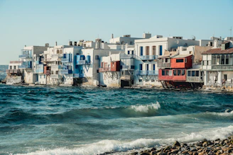 A row of houses sitting on top of a beach next to the ocean