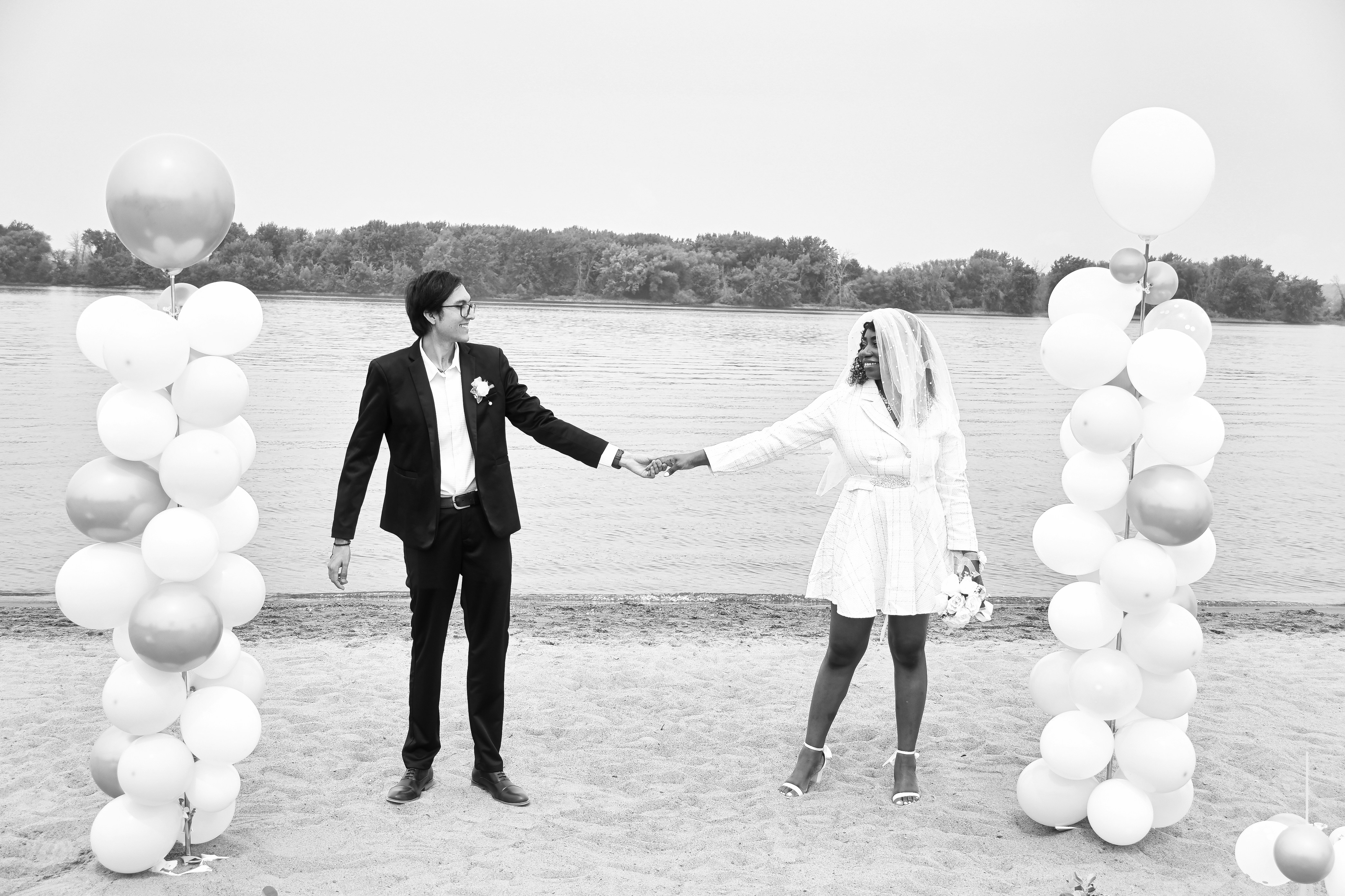 Un hombre y una mujer tomados de la mano frente a globos