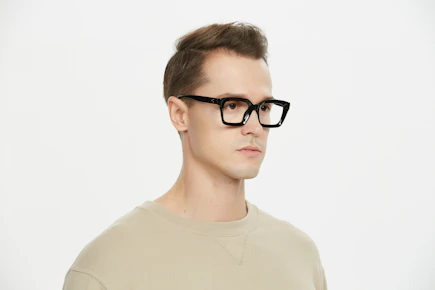 A man wearing glasses and a tan shirt