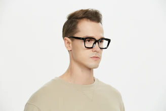 A man wearing glasses and a tan shirt