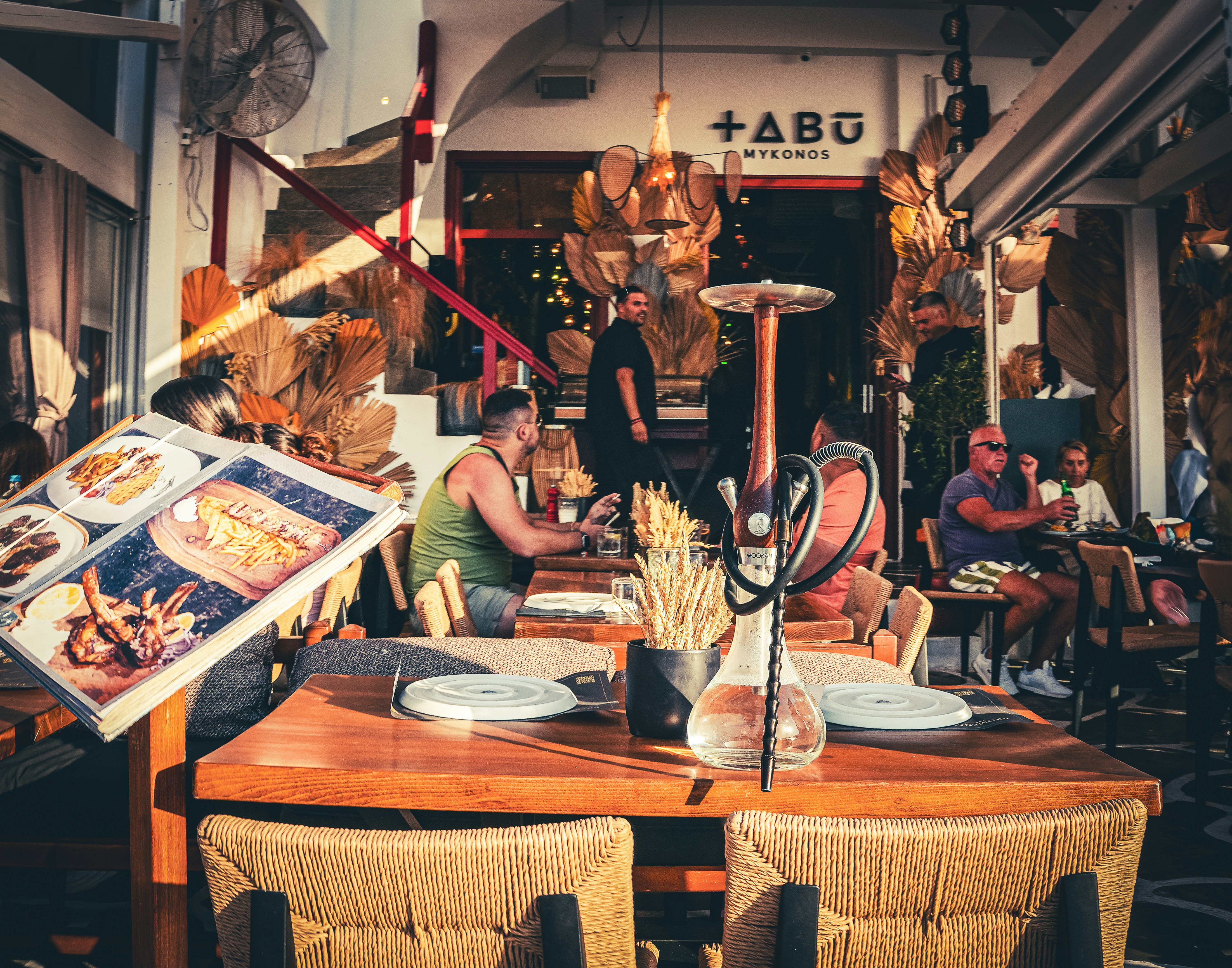 A group of people sitting around a wooden table, 