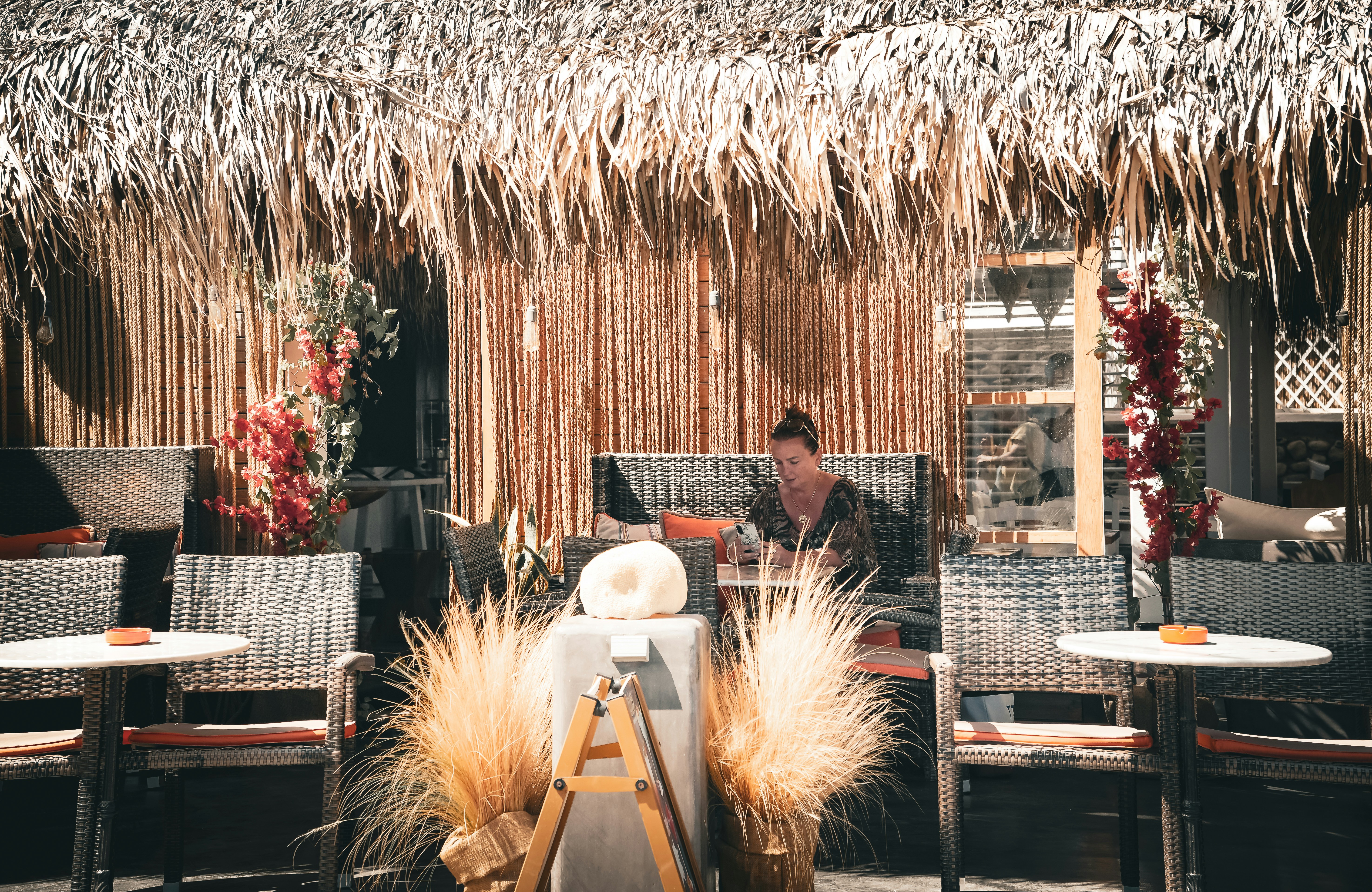 A man sitting at a table in front of a straw hut
