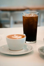 A cup of coffee sitting on top of a white table