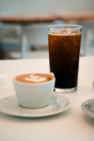 A cup of coffee sitting on top of a white table