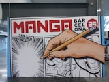A hand writing on a sign with a pencil