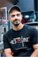A man sitting in a gym wearing a black shirt